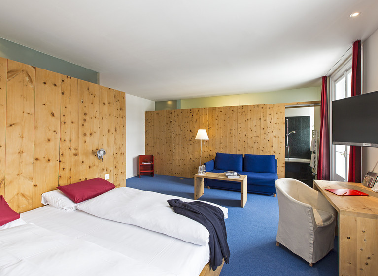 Doppelbett im Zimmer des Hotel Castell im Engadin