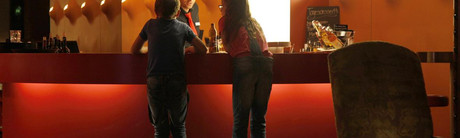 Personen stehen an der roten Bar des Hotel Castell im Engadin